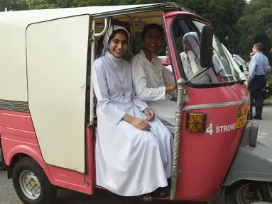 Para biarawati Pakistan duduk dengan becak merah muda sebelum aksi untuk meningkatkan kesadaran wanita di Lahore, (14/10). Becak merah muda dipegang oleh sekelompok wanita untuk menunjukkan kesetaraan dan pemberdayaan perempuan. (AFP PHOTO / Arif Ali)