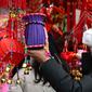 Seorang pria berbelanja dekorasi untuk perayaan Tahun Baru  Imlek di sebuah pasar di Provinsi Anhui, China, 23 Januari 2020. China menutup sebuah kota berpenduduk lebih dari 11 juta orang dalam upaya memerangi wabah virus corona, tindakan yang belum pernah terjadi sebelumnya.  (AP/Mark Schiefelbein)