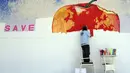 Seniman asal Albania itu membuat karya seni mozaik bergambar buah apel dari Taman Eden yang memiliki bekas gigitan Adam dan Hawa di Fier, Albania, Jumat (18/7/14). (REUTERS/Arben Celi)