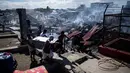 Sejumlah warga membawa barang miliknya saat rumah-rumah mereka hangus terbakar di sebuah daerah kumuh di Navotas, Manila (8/11). Dilaporkan sekitar 150 keluarga terkena dampak kebakaran tersebut. (AFP Photo/Noel Celis)