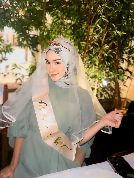 Di momen bridal shower-nya, Melody Prima tampil menawan dalam balutan dress berlengan puff warna hijau sage. Dress-nya ia padukan dengan hijab bermotif warna senada. [@melodyprima]
