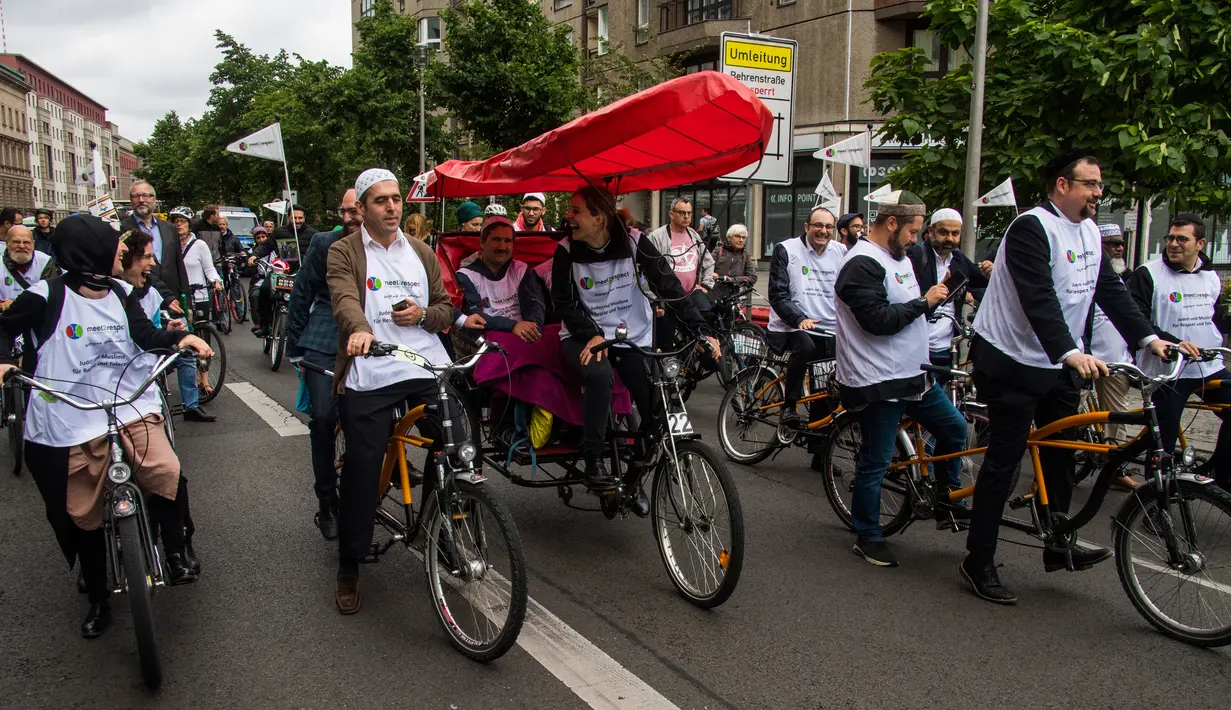 Imam Osman Oers dan Rabbi Akiva Weingarten bersama peserta lain mengayuh sepeda tandem di  Berlin, 24 Juni 2018. Meningkatnya anti-semitisme dan serangan terhadap Muslim di Jerman beberapa waktu lalu menjadi alasan kegiatan ini. (AFP/John MACDOUGALL)
