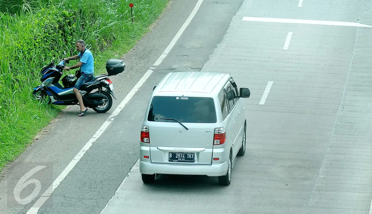 Pengendara motor berusaha memutar arah setelah memasuki Tol Ulujami - Serpong, Tangerang Selatan, Jumat (14/4). Minimnya rambu dan penjagaan petugas, membuat pengendara motor tersebut terjebak masuk ke jalur menuju pintu Tol. (Liputan6.com/Helmi Afandi)