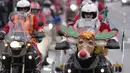 Pengendara sepeda motor yang mengenakan kostum Sinterklas mengendarai motor mereka selama parade Sinterklas di Beograd, Serbia, Minggu (26/12/2021). Mereka melakukan konvoi menuju rumah sakit anak-anak untuk membagikan mainan hadiah Natal kepada pasien di sana. (AP Photo/Darko Vojinovic)