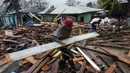 Seorang pria membawa sebatang kayu untuk memperbaiki rumahnya setelah melintas Badai Iota, di Bilwi, Puerto Cabezas, Nikaragua (17/11/2020). (AFP/Inti Ocon)
