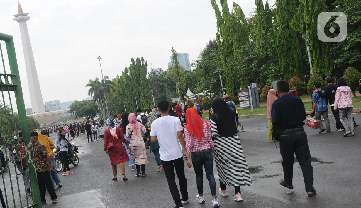 Warga berjalan-jalan di kawasan Monumen Nasional, Jakarta, Rabu (25/12/2019). Libur perayaan Natal 2019 dimanfaatkan warga Jakarta dan sekitarnya berwisata di Monumen Nasional. (Liputan6.com/Helmi Fithriansyah)