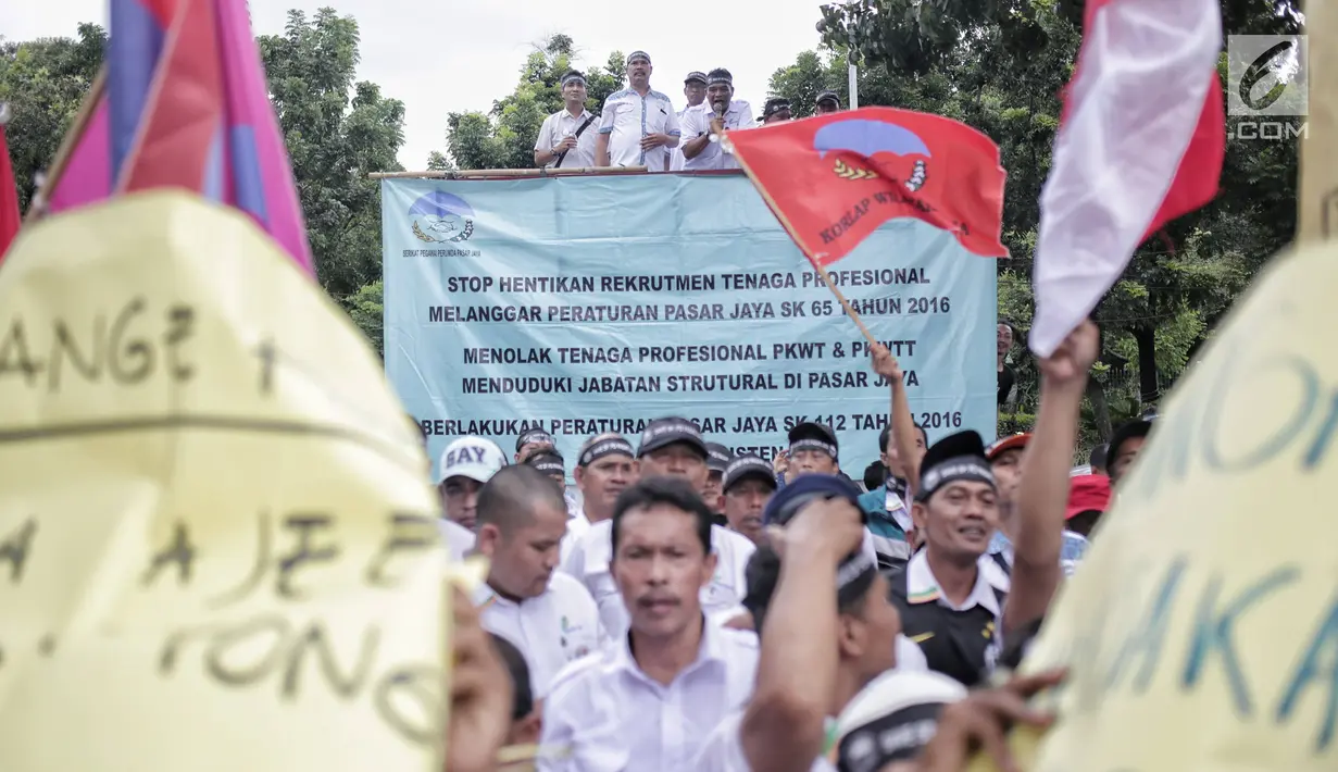 Massa dari Serikat Pegawai PD Pasar Jaya membentangkan spanduk saat berunjuk rasa di Balai Kota DKI Jakarta, Rabu (31/1). Dalam aksinya, mereka menolak tenaga profesional PKWT & PKWTT yang Kolusi, korupsi, Nepotisme (KKN).  (Liputan6.com/Faizal Fanani)