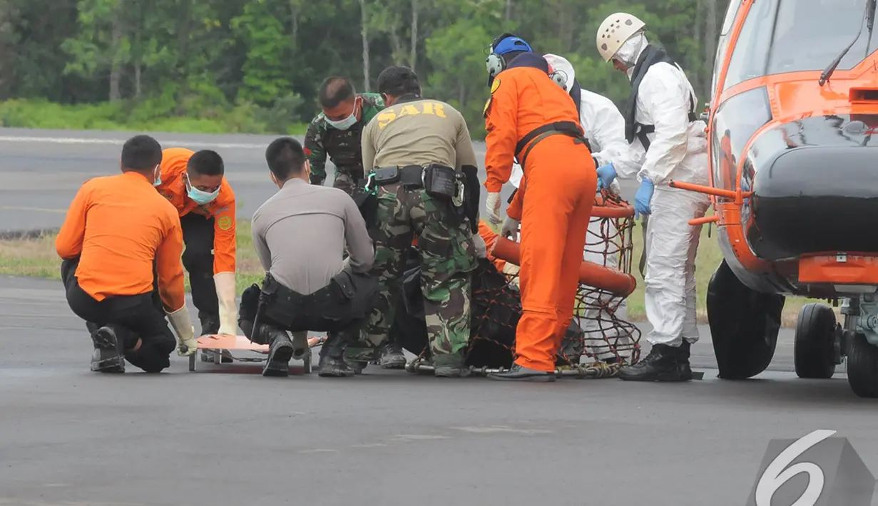 Petugas gabungan bergegas membawa tandu untuk memindahkan kantong berisi jenazah penumpang AirAsia QZ8501, Lanud Iskandar, Pangkalan Bun, Kalteng, Rabu (8/1/2015). (Liputan6.com/Herman Zakharia)