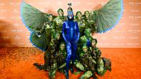 Sementara wajahnya mengenakan topeng serupa burung cantik ini, lengkap dengan kristal di bagian atas kepala, hingga paruh besar yang mirip dengan aslinya. (Photo by Evan Agostini/Invision/AP)