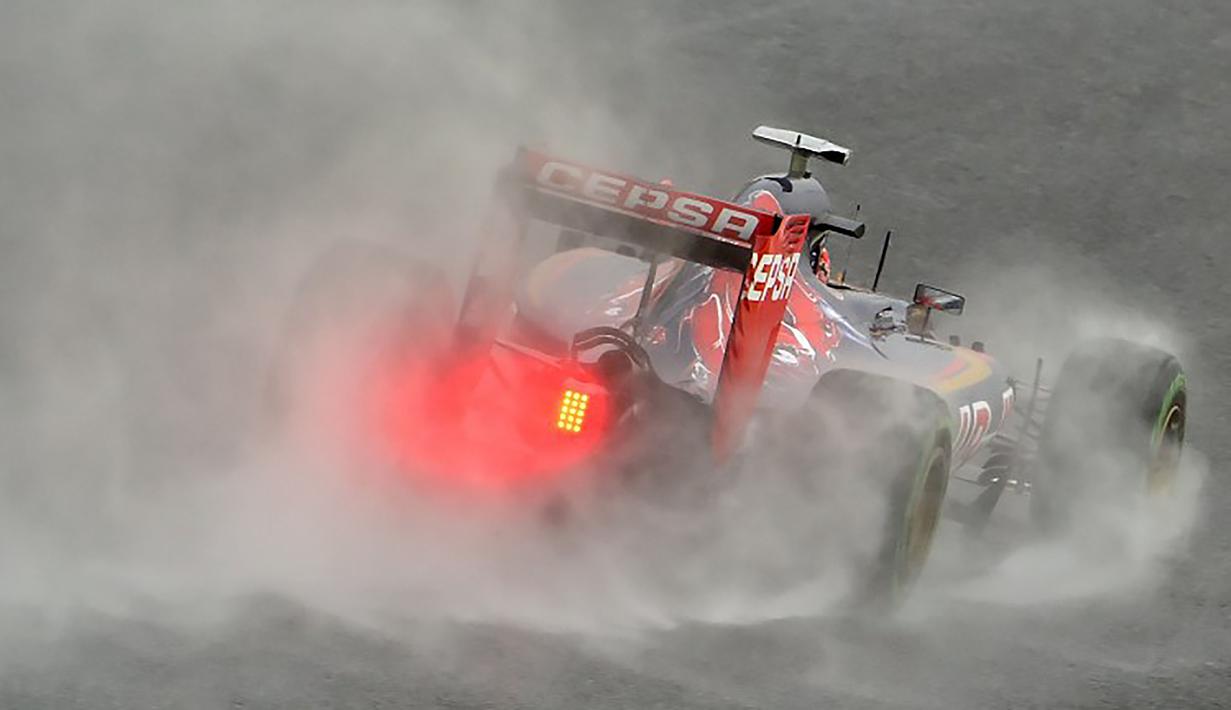 Mobil yang dikendarai pebalap F1 dari tim Toro Rosso, Max Verstappen saat melepati lintasan yang basah saat mengikuti sesi latihan bebas ke-3 jelang GP Jepang di Sirkuit Suzuka, Jepang, Jumat (25/9/2015). (AFP Photo/Kazuhiro Nogi)