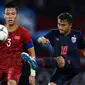 Duel pemain Vietnam, Que Ngoc Hai, dengan gelandang Timnas Thailand, Chanathip Songkrasin, saat kedua tim bertemu di kualifikasi Piala Dunia 2022 di Thammasat Stadium (5/9/2019).  (AFP/Chalinee Thirasupa)