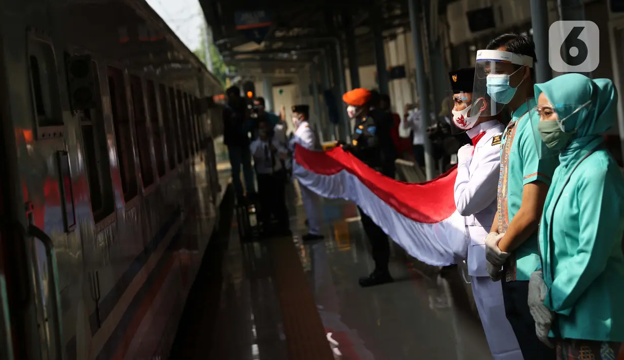 Personel Paskibra membentangkan bendera Merah Putih di Stasiun Pasar Senen, Jakarta, Senin (17/8/2020). Dalam rangka peringatan ke-75 tahun Hari Kemerdekaan Indonesia, PT KAI Daop 1 Jakarta mengadakan upacara pembentangan Bendera Merah Putih sepanjang 17 meter. (Liputan6.com/Helmi Fithriansyah)