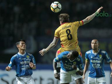 Pemain Persib Bandung, Ezechiel Ndouasel  berebut bola dengan pemain Mitra Kukar, Danny Guthrie pada laga Liga 1 Indonesia di GBLA, (8/4/2018). Persib Bandung menang 2-0. (Bola.com/Nick Hanoatubun)