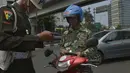 Personel Polisi Militer memeriksa kelengkapan surat-surat kendaraan milik anggota TNI AL ketika berlangsungnya Operasi Zebra 2014 di sekitar Pasar Senen, Jakarta, Rabu (26/11). (ANTARA FOTO/Saptono)