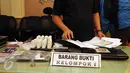Petugas merapikan barang bukti yang disita dari tersangka aksi penipuan melalui SMS saat rilis di Mapolda Metro Jaya, Sabtu (7/11/2015). Polda Metro Jaya mengungkap kasus penipuan melalui SMS dan meringkus 14 tersangka. (Liputan6.com/Helmi Fithriansyah)