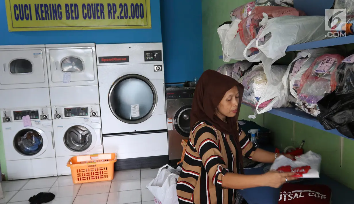 Pekerja tengah merapihkan pakaian di toko laundry di Jakarta, Rabu (20/6). Libur lebaran banyak jasa laundry kebanjiran order hingga 100 karena banyaknya para pembatu rumah tangga yang mudik lebaran. (Liputan6.com/Angga Yuniar)