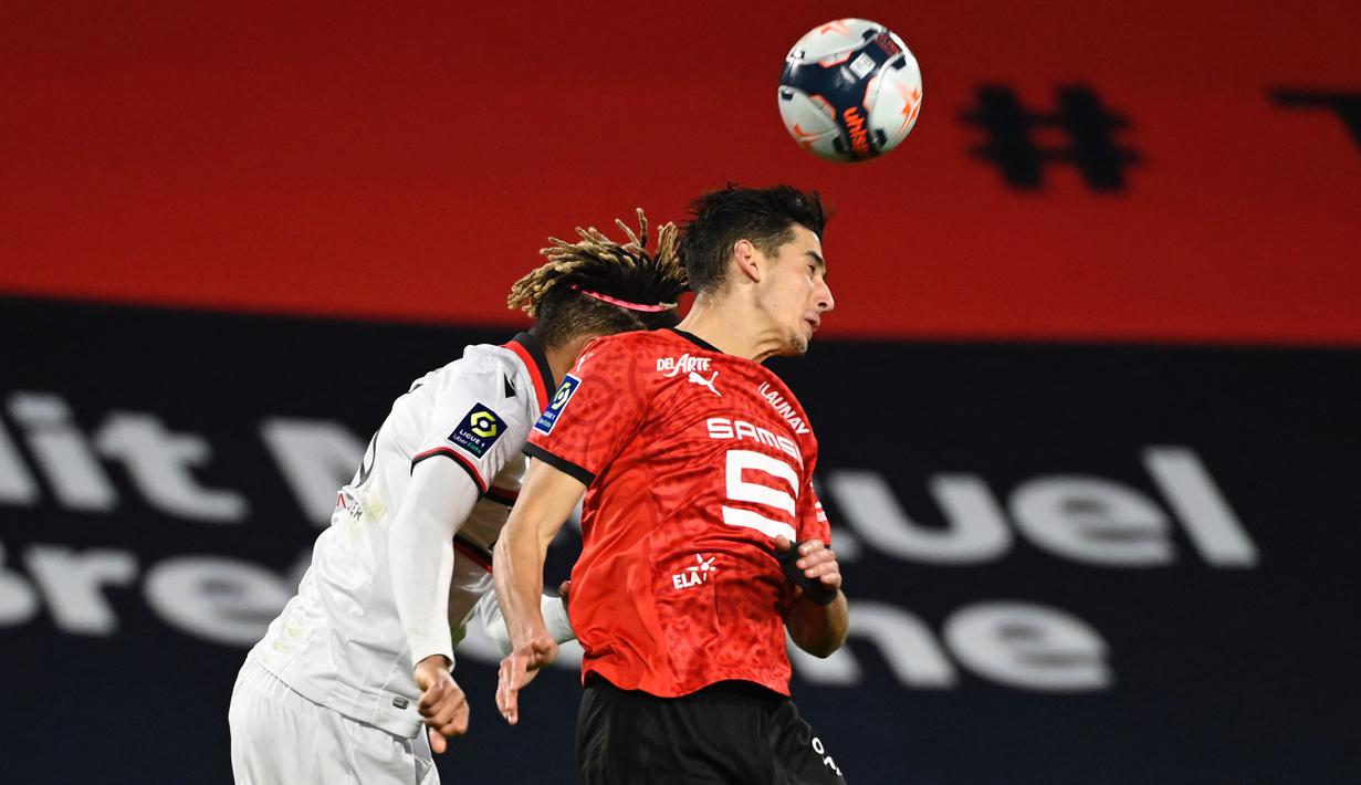 Bek Rennes, Nayef Aguerd (kanan) berduel udara dengan bek Nice, Jean-Clair Todibo dalam laga lanjutan Liga Prancis 2020/21 pekan ke-27 di Roazhon Park Stadium, Rennes, Jumat, (26/2/2021). Rennes kalah 1-2 dari Nice. (AFP/Damien Meyer)