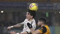 Bek Arsenal, Hector Bellerin melompat untuk melakukan sundulan saat berebut bola dengan penyerang Wolverhampton Wanderers, Pedro Neto pada pekan ke-22 Liga Inggris di stadion Mollineux, Rabu (3/2/2021) dini hari WIB. Arsenal harus pulang dengan tangan hampa usai kalah 1-2. (Cath Ivill/Pool via AP)
