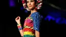 Model berpose di atas catwalk mengenakan busana yang berwarna-warni lengkap dengan aksesoris kepala yang menyerupai mahkota dari aneka bunga saat pergelaran Biofashion di Cali, Kolombia (19/11). (Reuters/Jaime Saldarriaga)