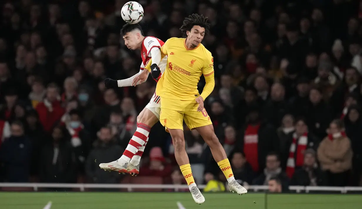 Penyerang Arsenal, Gabriel Martinelli berebut bola udara dengan bek Liverpool, Trent Alexander-Arnold pada pertandingan leg kedua semifinal Piala Liga Inggris di Stadion Emirates di London, Jumat (21/1/2022). Liverpool menang atas Arsenal 2-0. (AP Photo/Matt Dunham)