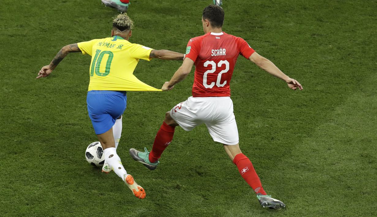 Striker Brasil, Neymar, berusaha melewati pemain Swiss, Fabian Schaer, pada laga Piala Dunia di Stadion Rostov, Rusia, Senin (17/6/2018). Dilanggar sebanyak 10 kali membuat Neymar masuk rekor di Piala Dunia. (AP/Andrew Medichini)