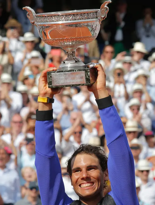 Petenis Spanyol, Rafael Nadal mengangkat trofinya setelah mengalahkan Stan Wawrinka pada final Prancis Terbuka di Roland Garros, Minggu (11/6). Nadal unggul dengan skor 6-2, 6-3, 6-1 untuk meraih gelar kesepuluh atau La Decima. (AP Photo/Michel Euler)
