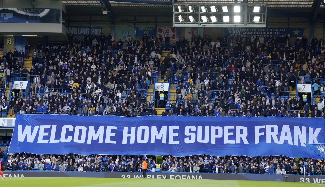 Suporter membentangkan spanduk sambutan untuk Frank Lampard saat melawan Brighton and Hove Albion pada pekan ke-31 Premier League 2022/2023, Sabtu (15/4/2023). Frank Lampard menjalani laga kandang pertamanya pasca-pelantikan kembali sebagai pelatih Chelsea. Momen comeback sang legenda ke Stamford Bridge berakhir pahit saat menjamu Brighton & Hove Albion. (AP Photo/Kirsty Wigglesworth)
