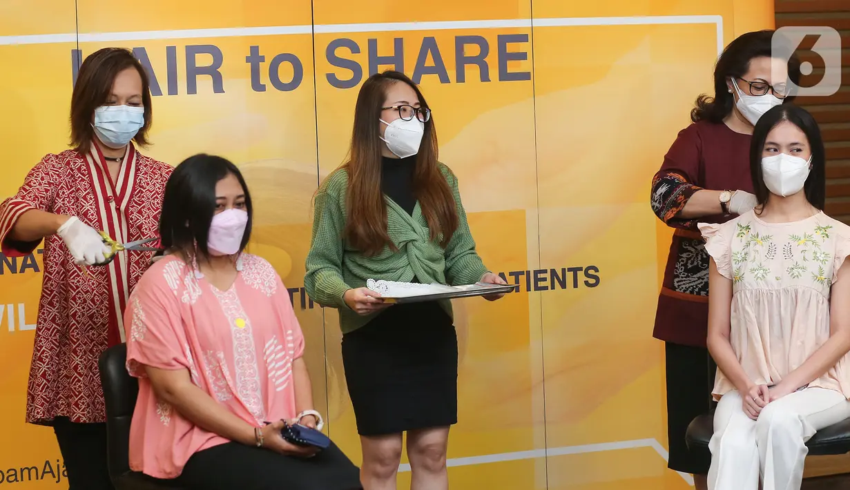 Yayasan Kanker Indonesia (YKI) Novelia Rajaguguk (kiri) dan Direktur MRCCC Siloam Hospitals Semanggi Adityawati Ganggaiswari (kanan) saat memotong rambut donatur pada kegiatan Hair to Share di MRCC Siloam Hospitals Semanggi, Jakarta, Rabu (03/02/2021). (Liputan6.com/Fery Pradolo)