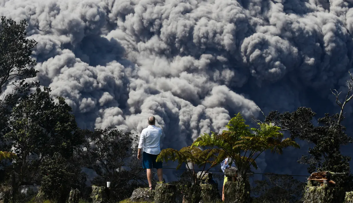 Jack Jones mengambil gambar saat kepulan asap abu vulkanik gunung Kiluaea berembus di country club di Volcano, Hawaii (21/5). Lava dari gunung Kilauea Hawaii mengalir ke laut dan memicu reaksi kimia yang menciptakan asap hitam. (AP Photo/Jae C. Hong)
