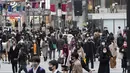 Orang-orang, yang mengenakan masker wajah, berjalan melintasi persimpangan di Tokyo (11/12/2020). Kurangnya tindakan pemerintah telah memicu kekhawatiran tentang kenaikan lebih lanjut selama musim liburan. (AP Photo / Hiro Komae)