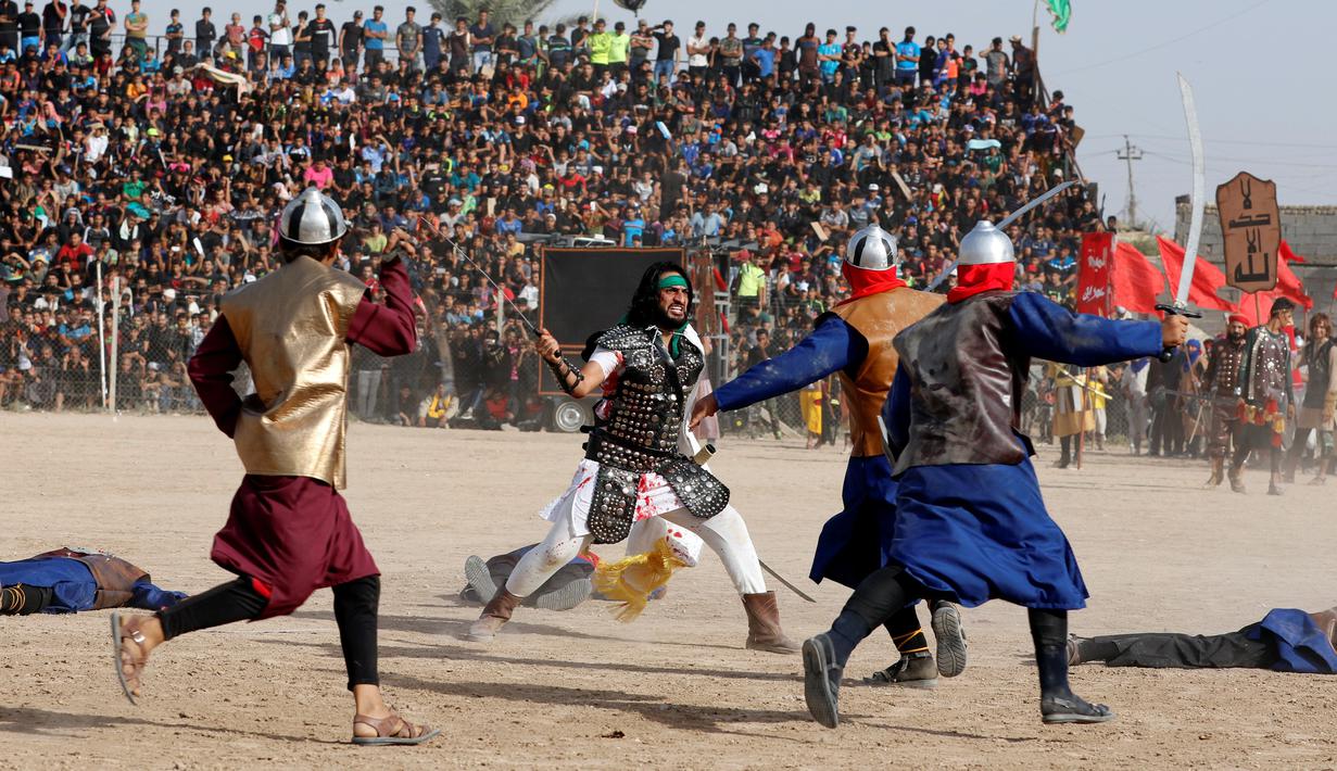 Aktor menggunakan pakaian prajurit kuno saat melakukan reka ulang adegan Pertempuran Karbala yang menewaskan Husain bin Ali, di Sadr City, Baghdad, Irak (12/10). Pertempuran Karbala terjadi pada 10 Muharram 61 H abad ke-7 Masehi. (REUTERS/Ahmed Saad)