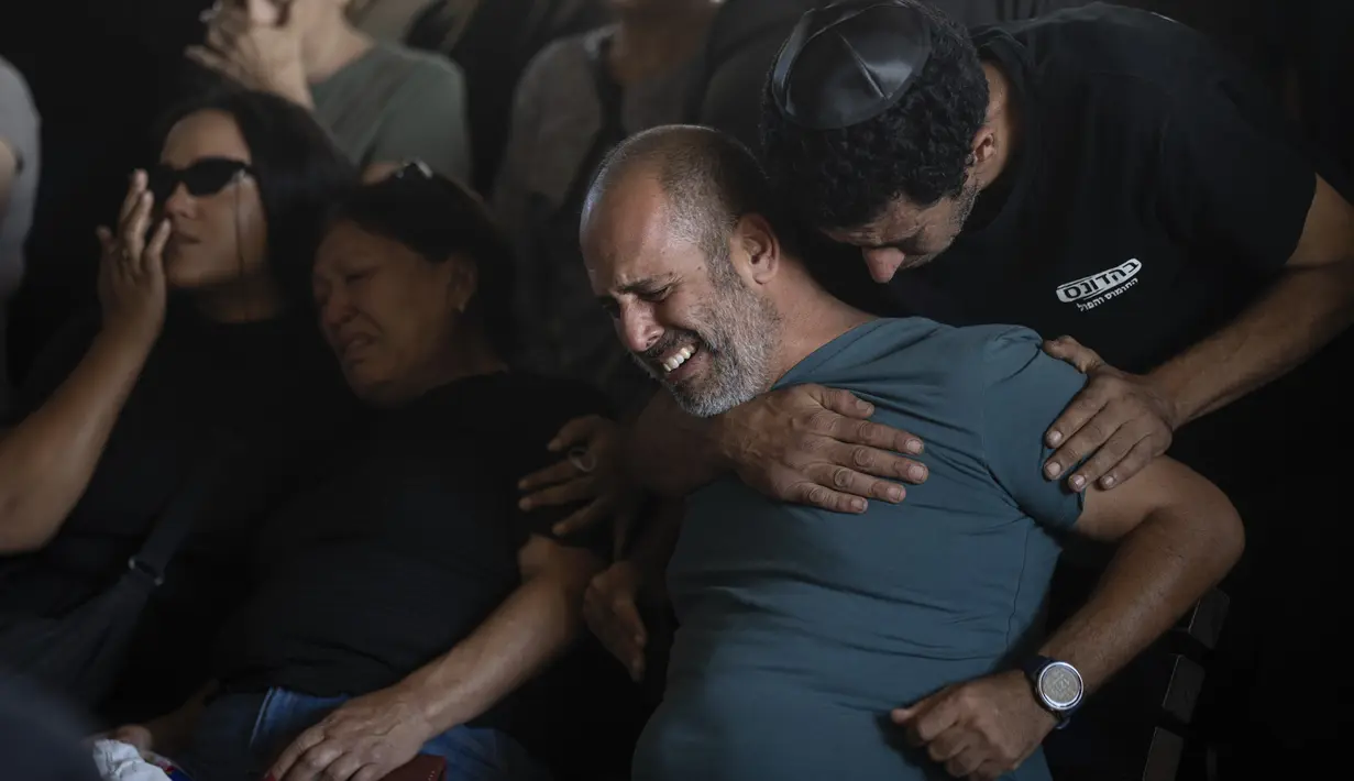 Orang-orang yang dicintai oleh seorang tentara Israel yang telah meninggal, wajah mereka diliputi kesedihan saat mereka berduka. (AP Photo/Petros Giannakouris)