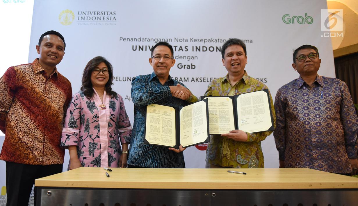 Rektor Universitas Indonesia Muhammad Anis (ketiga kiri) bersalaman dengan President of Grab Indonesia Ridzki Kramadibrata (kedua kanan) usai menandatangani Nota Kesepakatan Bersama Universitas Indonesia dengan Grab di Universitas Indonesia, Depok, Kamis (16/5/2019). (Liputan6.com/Herman Zakharia)