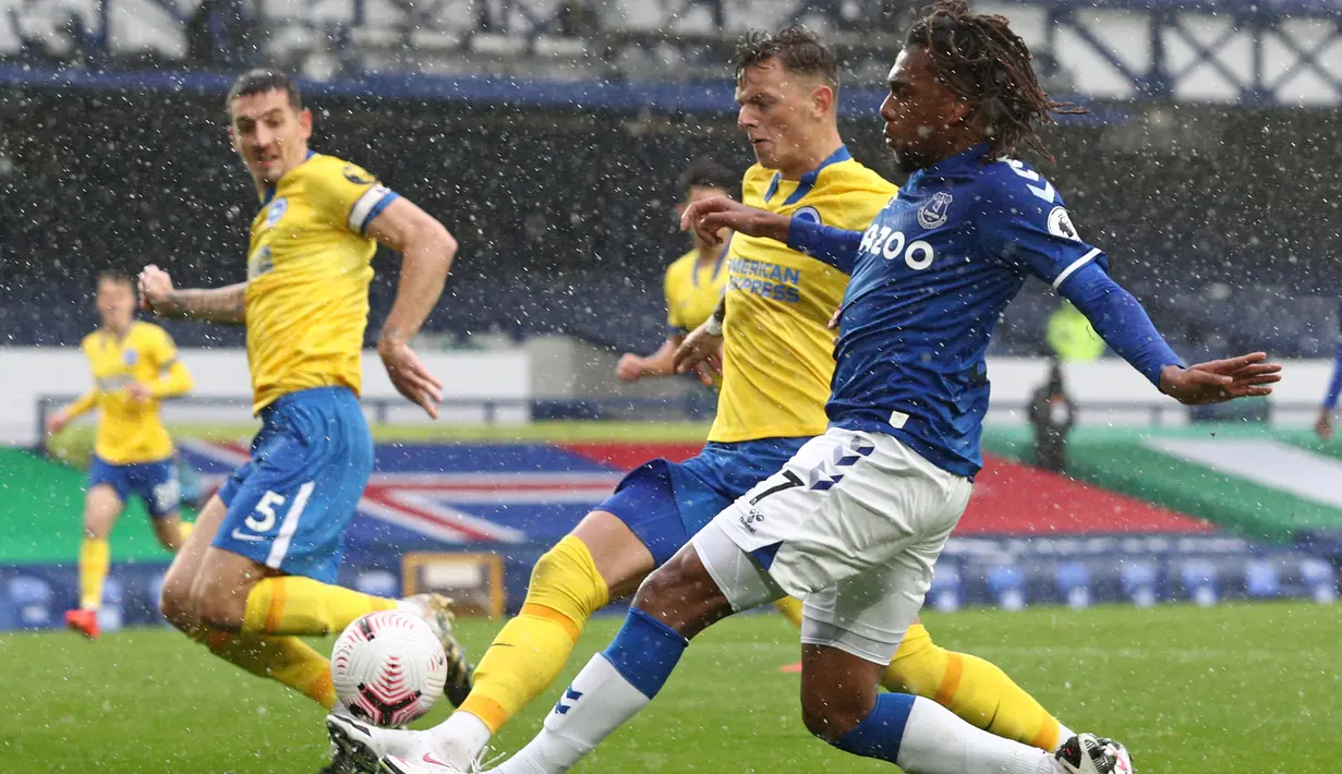 Gelandang Everton, Alex Iwobi, berusaha melewati pemain Brighton pada laga lanjutan Liga Inggris di Stadion Goodison Park, Sabtu (3/10/2020) malam WIB. Everton menang 4-2 atas Brighton. (AFP/Jan Kruger/pool)