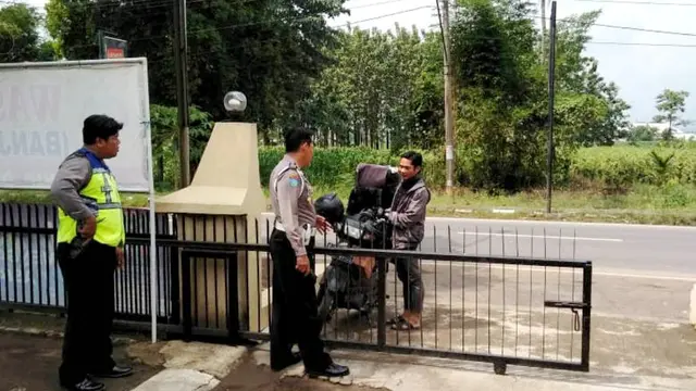 Polisi menghentikan seorang pengendara sepeda motor pembawa tas besar, yang ternyata kurir perusahaan jasa pengiriman barang sebelum masuk ke Polsek Bantar Bolang, Pemalang. (Foto: Liputan6.com/Polres Pemalang/Muhamad Ridlo)