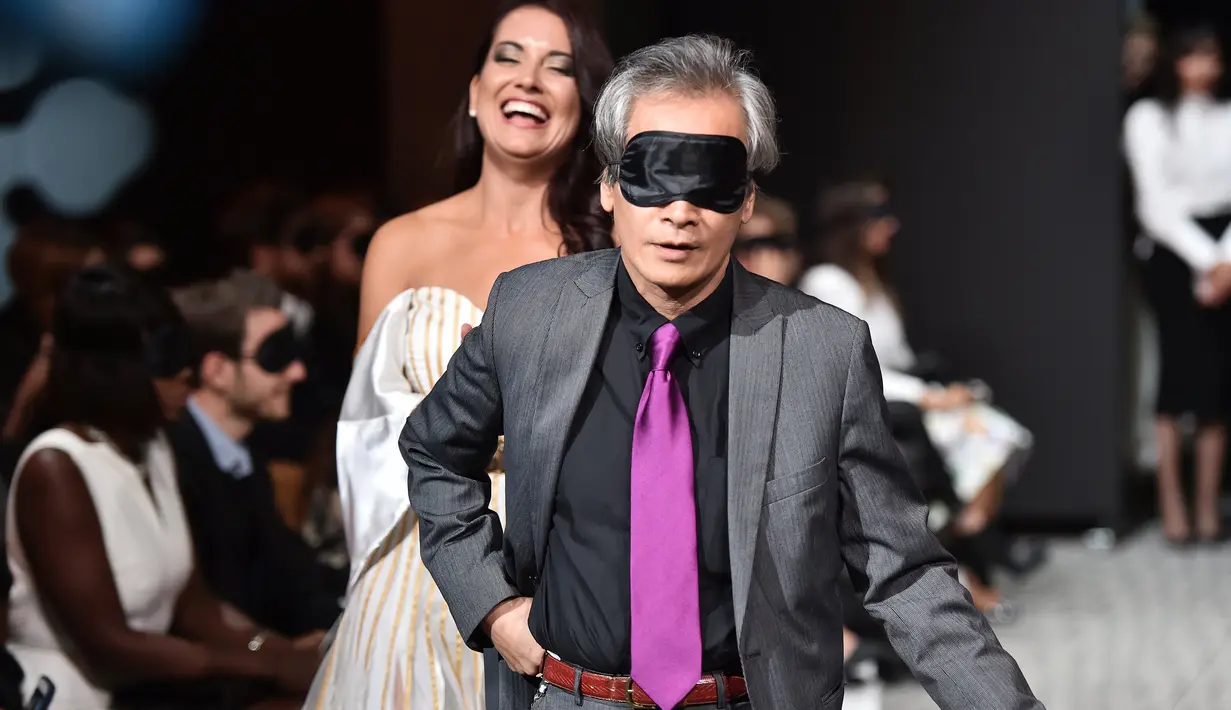 Seorang partisipan mengenakan penutup mata ketika mencoba berjalan di catwalk pada peragaan busana dengan model tunanetra selama pagelaran Paris Fashion Week di Paris, Rabu (5/10). (AFP PHOTO/Christophe Archambault)