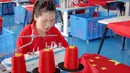 Pekerja membuat bendera nasional di sebuah pabrik menjelang Hari Nasional di Wuyi, Provinsi Zhejiang, China, 28 September 2021. Hari Nasional adalah sebuah hari libur nasional di China untuk merayakan hari kebangsaan mereka dan diperingati pada tanggal 1 Oktober setiap tahun. (STR/AFP)