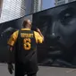 Erikk Aldridge merekam mural yang menggambarkan Kobe Bryant di Los Angeles, Rabu, 24 Agustus 2022.  Berukuran 125 kaki kali 32 kaki, mural tersebut menampilkan potret Bryant, yang meninggal pada tahun 2020 pada usia 41 tahun dalam kecelakaan helikopter. (AP Photo/Jae C. Hong)