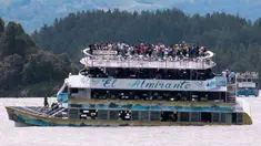 Penumpang terlihat berada di atas kapal wisata Almirante sesaat sebelum tenggelam di sebuah waduk di Kolombia barat daya, Minggu (25/6). Sedikitnya sembilan orang meninggal dunia dan 28 lainnya hilang dalam peristiwa itu. (Juan QUIROZ/AFPP)