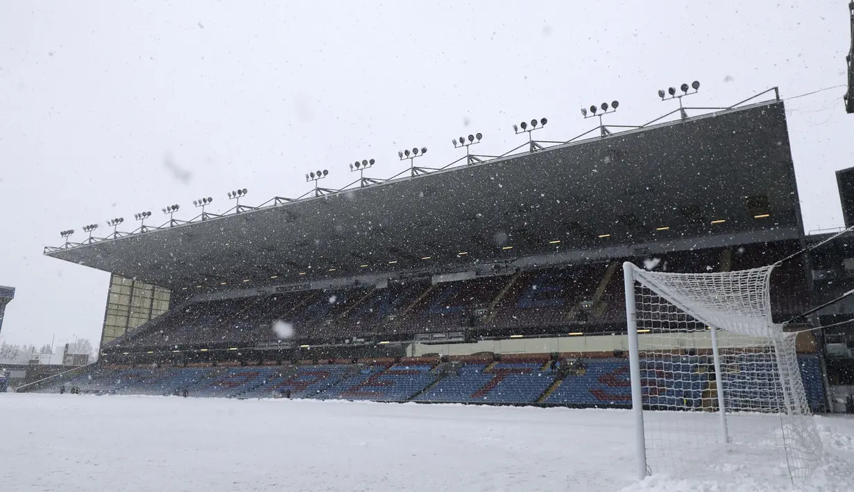 Pihak Burnley selaku tuan rumah sudah berusaha keras, tapi dalam waktu 10 menit saja, lapangan sudah kembali tertutup salju lagi. (AP Photo/Rui Vieira)