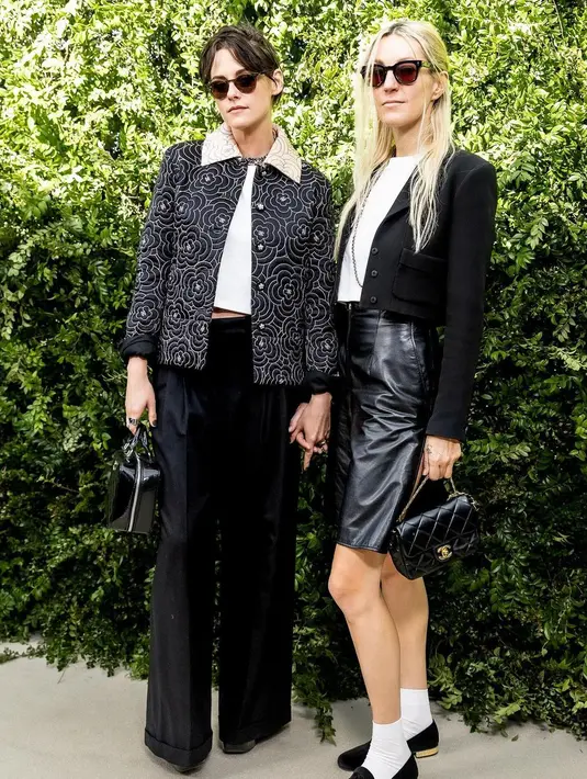 <p>Tak sendirian, Kristen Stewart juga hadir bersama tunangannya, Dylan Meyer. Meyer tampil dalam balutan blus putih, rok kulit hitam, jaket cropped, dan tas Chanel. [@justjared]</p>