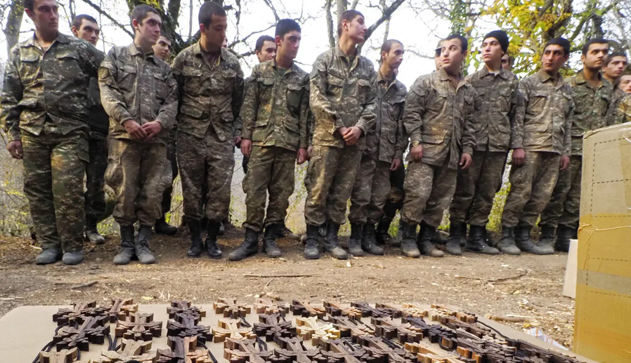 Tentara etnis Armenia berdiri sebelum upacara pembaptisan di sebuah kamp militer dekat garis depan konflik di wilayah separatis Nagorno-Karabakh, Azerbaijan, Senin (2/11/2020). Pasukan Armenia dan Azerbaijan saling menyalahkan atas serangan baru selama perebutan Nagorno-Karabakh. (AP Photo)