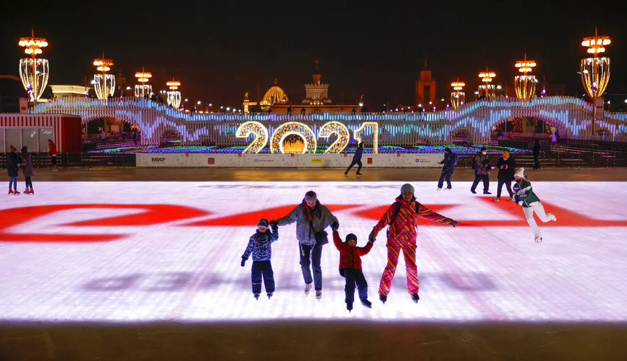 Sejumlah orang berseluncur saat pembukaan arena seluncur es di VDNKh (Pameran Prestasi Ekonomi Nasional), Moskow, Rusia, Jumat (27/11/2020). Area tersebut terbuat dari lapisan es buatan lebih dari 20.000 meter persegi. (AP Photo/Alexander Zemlianichenko)