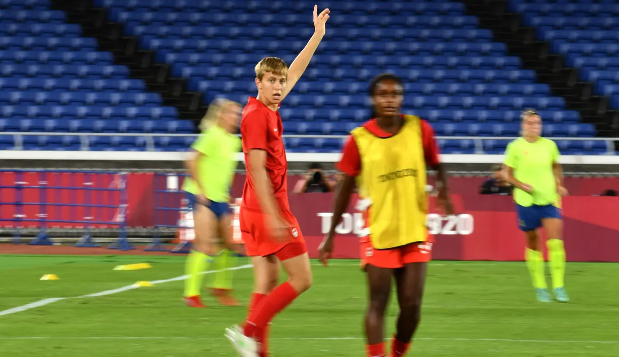 Gelandang Kanada Quinn melakukan pemanasan sebelum laga sepak bola terakhir putri Olimpiade Tokyo 2020 melawan Swedia di Stadion Internasional Yokohama di Yokohama pada 6 Agustus 2021. Quinn jadi atlet transgender pertama yang memenangkan medali Olimpiade. (Loic VENANCE/AFP)