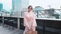 Cocok untuk kondangan, bisa tiru gaya Enzy Storia berikut ini. Padukan tunik warna pink dengan pleats skirt warna hitam, manis banget! (Instagram/enzystoria).