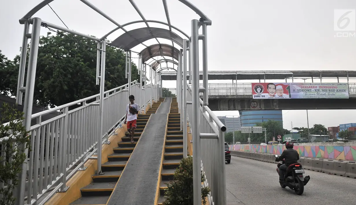 Pejalan kaki melintasi jembatan penyeberangan orang (JPO) di Jalan Yos Sudarso, Jakarta, Kamis (8/11). Kondisi JPO yang rusak menggangu kenyamanan dan keselamatan pejalan kaki. (Merdeka.com/Iqbal Nugroho)