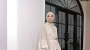 Shireen Sungkar mengenakan ling dress coklat lengan puff dengan akse lace yang senada di bagian depannya dipadukan kerudung coklat polos sambik membawa tas Dior. [@shireensungkar]
