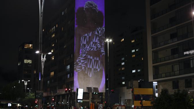 Gambar model di atas catwalk diproyeksikan pada sebuah gedung selama Sao Paulo Fashion Week di Sao Paulo, Brasil, Rabu (4/11/2020). Perancang busana meninggalkan catwalk dan mengandalkan teknologi digital untuk memamerkan karya koleksi spring/summer mereka. (AP Photo/Marcelo Chello)
