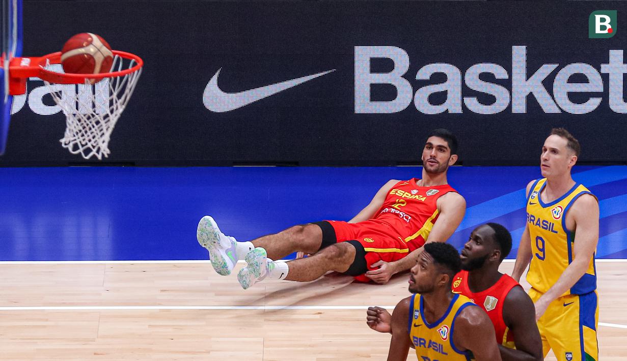 Pebasket Spanyol, Santiago Aldama terjatuh saat melakukan tripoin pada laga kedua Grup G Piala Dunia FIBA 2023 melawan Brasil di Indonesia Arena, Senayan, Jakarta, Senin (28/08/2023). Spanyol menang atas Brasil dengan skor 96-78. (Bola.com/Bagaskara Lazuardi)