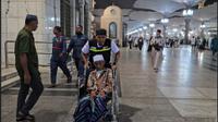 Petugas haji mengantar pulang jemaah haji lansia dari Masjid Nabawi menuju hotel menggunakan kursi roda. (FOTO: MCH PPIH ARAB SAUDI 2023)
